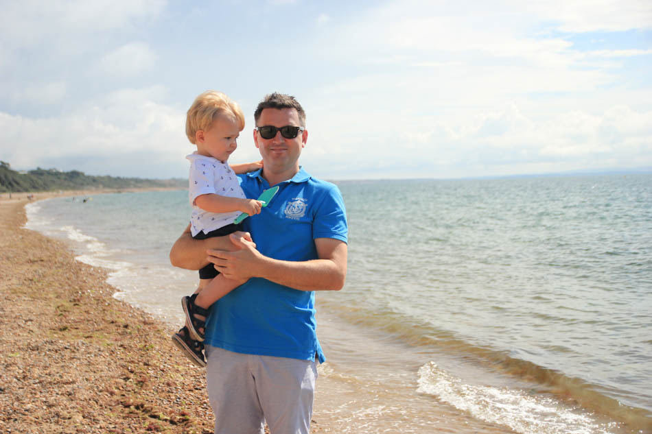 Nathan holding Teddy at Mudeford beach